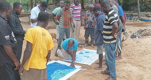 Stephen Kankam of Hen Mpoano explaining the scope of the area on a map to memsvabers of the community on the MPA