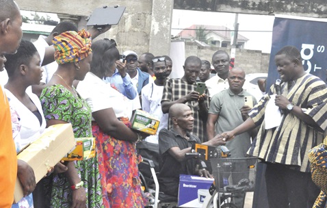 Togbe Anikpi III (2nd from left), Dufia of Ho-Heve, being assisted by Stephanie Oforiwah Asare (left),the Corporate Social Responsibility Coordinator of OneAfrica Markets, and Dr Doh to cut the tape to commission the borehole