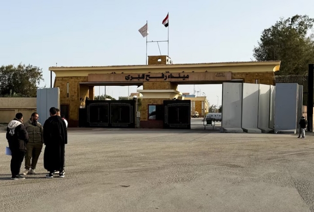 People stand near the Rafah border crossing between Egypt and the Gaza Strip, in Rafah, Egypt, January 27, 2026. REUTERS/Stringer