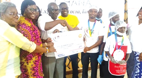 Michael Owusu-Manu (middle), Founder of the Cocoa Club Ghana, presenting the ultimate prize to Old Akyem Tafo R/C Basic School