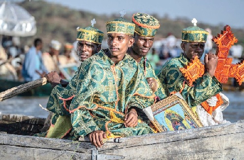 High priests riding in a boat as faithful celebrate Timket, the Ethiopian Epiphany, on lake Dembel, in Batu, Ethiopia