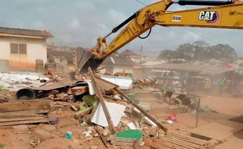 An excavator clearing some debris from the project site An excavator clearing some debris from the project site