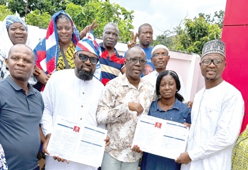 Alhaji Hamza Osumanu (right), New Juaben South Constituency Second Vice-Chairman hopeful, presenting his nomination forms to Yaw Peter Kosoe (middle), Chairman of the Election Committee of the NPP in Koforidua
