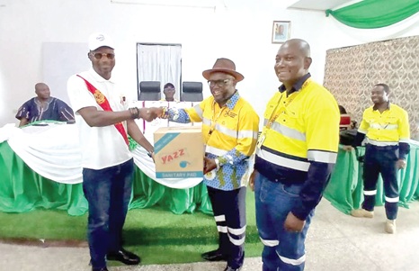 Dr Kenneth Ashigbey (middle), Chief Executive Officer, Ghana Chamber of Mines, being supported by Derek Boateng (right), Senior Manager in charge of sustainability and External Relations at Zijin Golden Ridge Limited to present a symbolic box of sanitary towels to Solomon Azubila, Birim North District Education Director