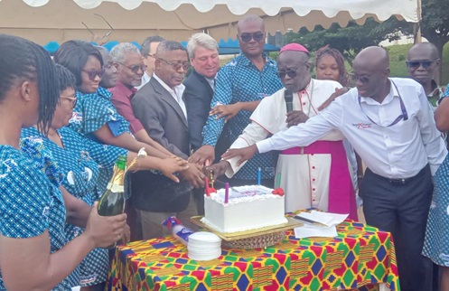 Professor Edward Tsiri Agbenyega (middle in suit), Medical Director of the centre, being assisted by Most Rev. Gabriel Justice Yaw Anokye, (2nd from right), Metropolitan Archbishop of the Catholic Archdiocese of Kumasi, other dignitaries and staff to jointly cut the anniversary cake 
