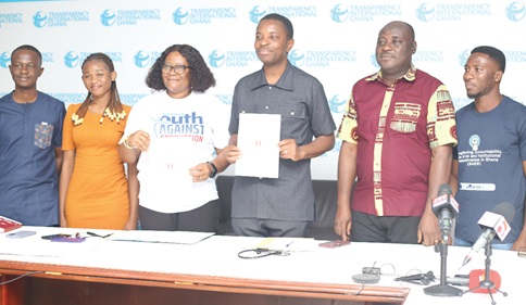Mary Awelana Addah (3rd from left) and Dr Emmanuel Odame (3rd from right), Chairman &amp; Founder, Honour Ghana, displaying the MOU after the signing ceremony. With them are some staff of Transparency International and Honour Ghana.  Picture: BENEDICT OBUOBI