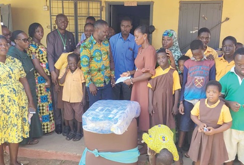 The Yilo Krobo Municipal Chief Executive, Francis Akumatey Addo, presenting an envelope to the Head of Department of Special Needs of the school, Alberta Amoatey