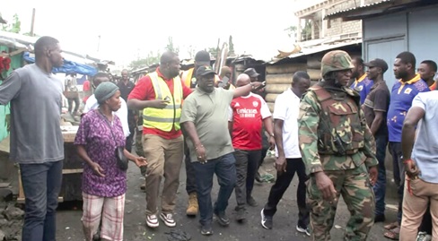 Richard Ofori-Agyeman Boadi (hand stretched), Chief Executive Officer, KMA, issuing a directive while leading the demolition exercise