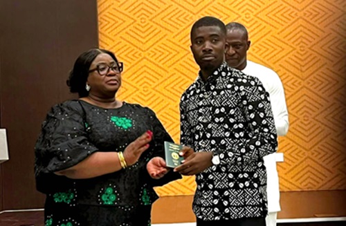 Khadijah Iddrisu (left),  Chief Director of the Ministry of Foreign Affairs, presenting a new chip-embedded passport to a beneficiary