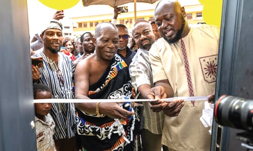 Nana Fe-Baamoah II, Chief of Asokwa, being assisted by Amoh Kamel (right), MCE for Asokwa Municipality, and Nii Adotey Mingle (2nd  from right), General Manager, MTN Ghana's Northern Business District, to cut the tape to inaugurate the centre