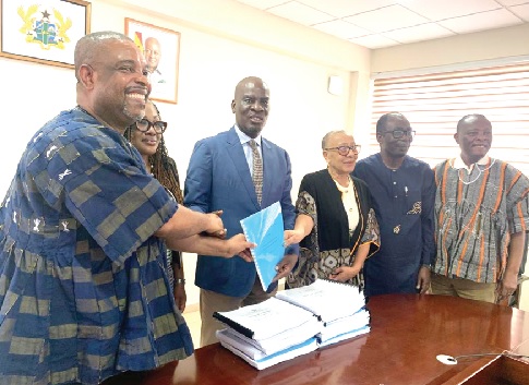 Prof. Samuel Ofori Bekoe (left), the Director-General of National Council for Curriculum and Assessment, presenting the revised curriculum report to Haruna Iddrisu (middle), the Minister of Education, as others look on