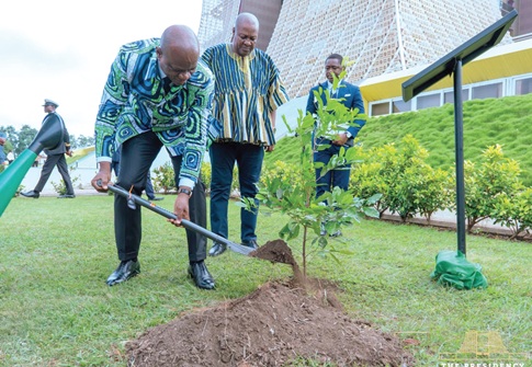 President Brice Clotaire Oligui Nguema planting  a tree at the Jubilee House while President John Mahama looks on