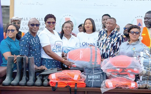 Dinah Kaleo-Bioh, Head, Business and Commercial Banking, Stanbic Bank, presenting the relief items to Alalzuuga Albert Akuka, Deputy Director-General in Charge of Livelihoods and Migration at NADMO