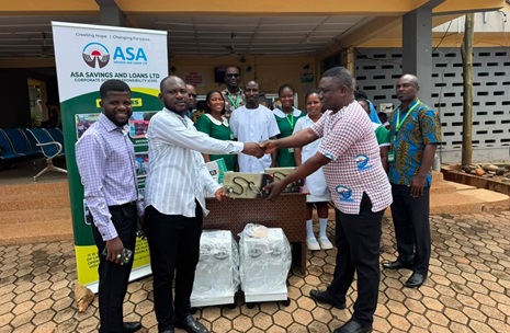 Eugene Owusu Biney (2nd from left), Madina Area Manager of ASA Savings and Loans Limited, presenting an item to Vincent Tameklo (right), the Head of Administration of the Atua Government Hospital