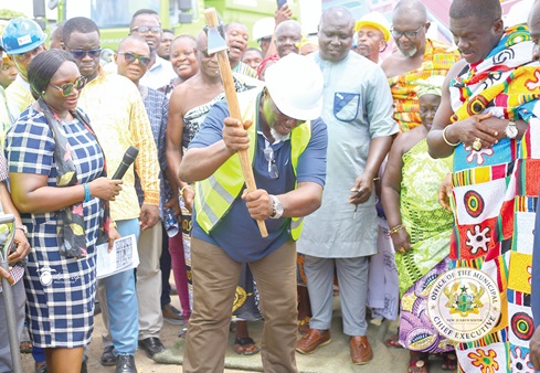 Ransford Owusu Boakye (with pickaxe), Municipal Chief Executive (MCE) for New Juaben South, officially cut the sod for construction works to start. Looking on are Nana Twumasi Danquah, Gyasehene of the New Juaben Traditional Area, and the assembly members