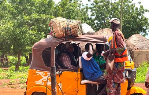 A revenue officer of the Tolon District Assembly taking a toll from trycicle operators  at the entrance of the market