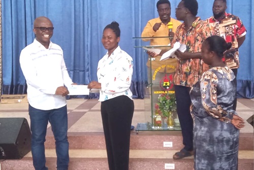 Dr Stephen Amoah (left), MP for Nhyiaeso, presenting a cheque to Ruth Frimpong Nuamah, one of the beneficiary students
