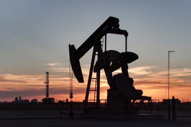 A drone view of a pump jack and drilling rig south of Midland, Texas, U.S. June 11, 2025. REUTERS/Eli Hartman/File Photo