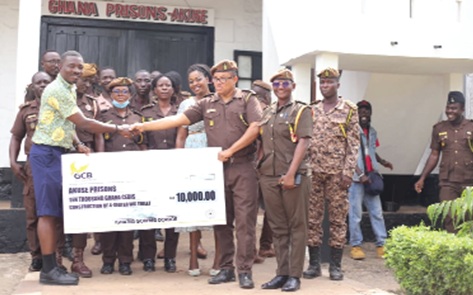 Ignatius Godfred Dordoe (left), DCE, Shai-Osudoku District Assembly, presenting a dummy cheque to Issifu Abdallah (right), Chief Superintendent of Prisons