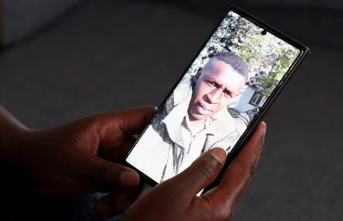 Felista Njoki, wife of Samuel Mwaura Wainaina who was recruited to fight in the Russia–Ukraine war, holds a phone displaying his photograph he sent her while in military gear, during a Reuters interview at their family home in Limuru, Kiambu County, Kenya, February 23, 2026. REUTERS/Monicah Mwangi
