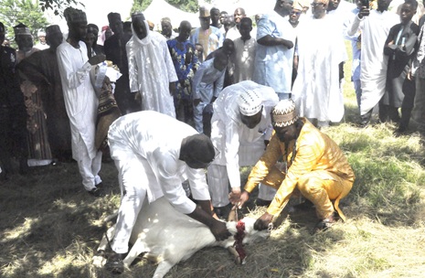 Alhaji Ali Mohamed (middle), the officiating Imam, slaughtering the ram Alhaji Ali Mohamed (middle), the officiating Imam, slaughtering the ram