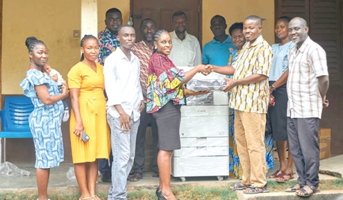 Salomey Appiah Adjei (4th from left), Operations Manager of the foundation, handing  over the learning materials to Harrison Mompi (2nd from right), headmaster of the school