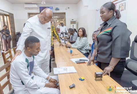 Samuel Okudzeto Ablakwa (2nd from left), Minister of Foreign Affairs, interacting with an applicant (seated) while a female staff  of the Ashanti Regional Passport Application Centre looks on