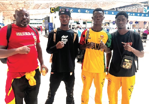 Coach Charles Quartey (left) and the three boxers at the Accra International Airport yesterday ahead of their departure for the championship