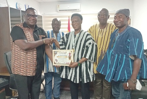 Morgan Ayawine (middle) receiving a citation for the award from Essel Kwame Reandorf (left), a representative of The Business Executive. With them are ICU national leaders