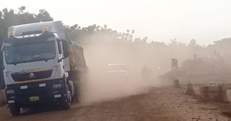 The road clouded with dust by a heavy duty vehicle