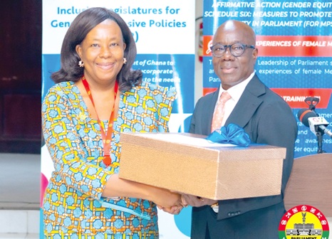 Dr Rasheed Draman (right), Executive Director, ACEPA, presenting a box of working tool documents to Dr Silvia Ani, Special Advisor to the Speaker on Gender and Health Matters
