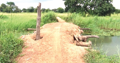 The temporary wooden structure residents use as bridge is frequently washed away by floods