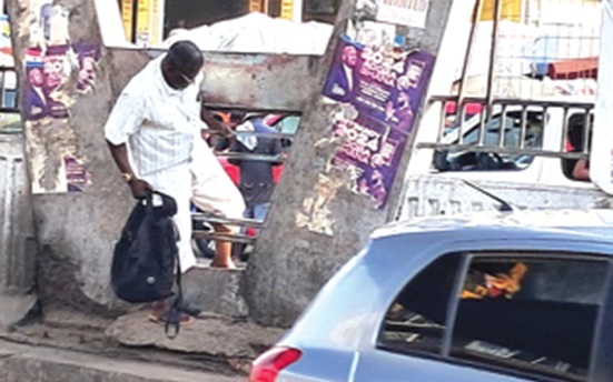 A pedestrian crossing the road under the Kaneshie footbridge A pedestrian crossing the road under the Kaneshie footbridge