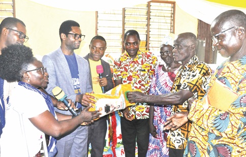  Prof. Augustina Naami (left), National Executive Committee Member of the Ministry, presenting an item to a beneficiary.