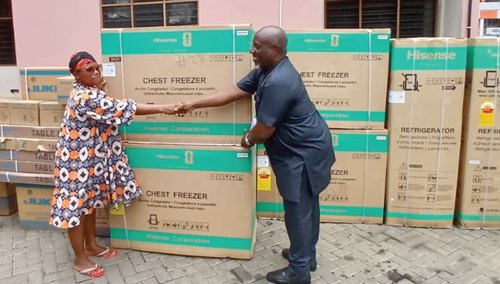 Ransford Owusu Boakye (right), Municipal Chief Executive for New Juaben South, presenting one of the items to a beneficiary in Koforidua