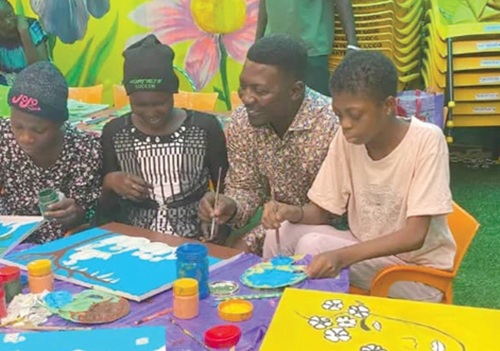 Nana Yaw Ampem-Darko Antwi (2nd from right) painting with some children at the library