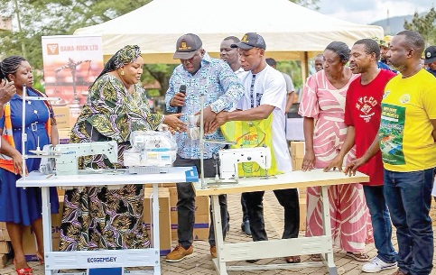 Eric Addae Boateng (middle), Business Development and Sustainability Manager of Bawa-Rock Limited, presenting the items to Faustilove Appiah Kanin (left), MCE for Obuasi