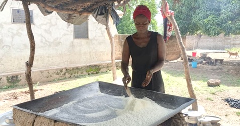 Biyinke Elizabeth is frying gari under smoke and heat at Chakori Biyinke Elizabeth is frying gari under smoke and heat at Chakori