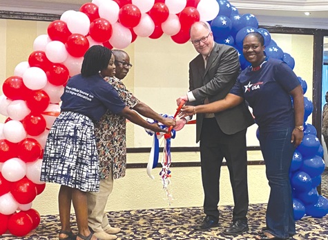 Rolf Olson (2nd right), Chargé d'Affaires, US Embassy in Ghana, being assisted by Nana Baffour Awuah (2nd from left), Director at the Ministry of Education, to open the fair. With them are staff of the embassy