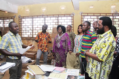 Patrick Awotwe (left), the Central Regional Book Depot Supply Officer, briefing the members of the committee on the quantities of textbooks supplied to the depot by the GES