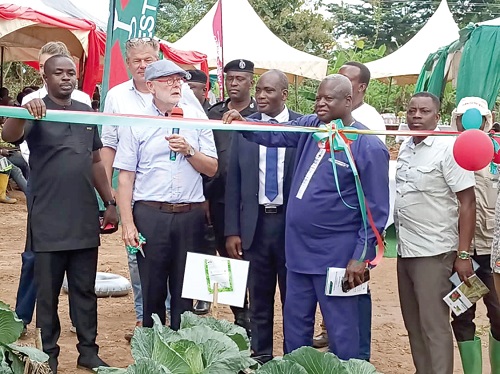 Jeroen Verheul (2nd from left), Netherlands Ambassador to Ghana, being assisted by Ansu Kumi (left), Sunyani Municipal Chief Executive, and Denis Abugri Amenga (2nd from right), Bono Regional Director of Agriculture, to inaugurate the learning farm