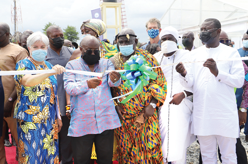  President Akufo-Addo being assisted by Ms Stephanie S. Sullivan (left), the US Ambassador to Ghana, to cut the tape to inaugurate the Pokuase Bulk Supply Point. With them are other dignitaries. Picture: SAMUEL TEI ADANO