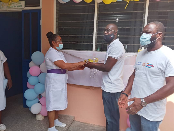 Vice President of the Rotary Club of Accra-Labone, Mr Carlis Arko helping the Deputy Director of Nursing Services of the Nsawam Government hospital, Madam Rosephilo Adomah, to cut tape to formally hand over the renovated ward