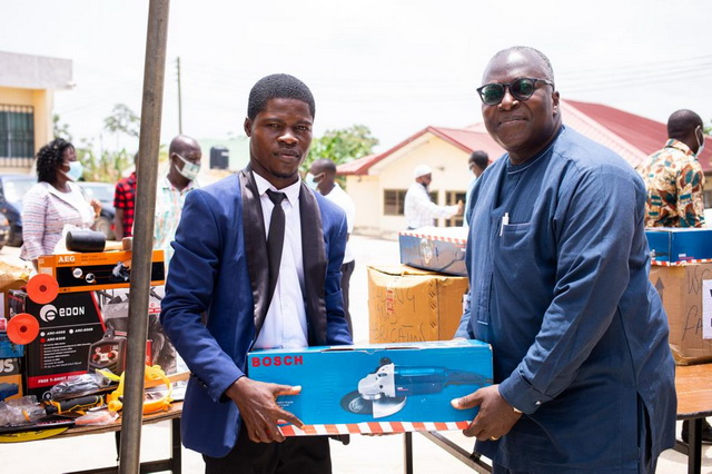 The General Manager, Corporate Affairs of WAPCo, Dr Isaac Adjei Doku presenting the tools to one of the beneficiaries