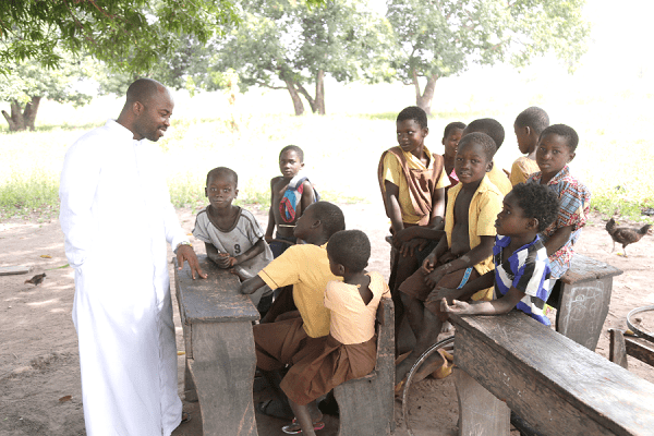 Rev Fr Stephen Sakpaku, the Parish Priest of the St Joseph the Worker Catholic Church at Maame Krobo interacting with the pupils Rev Fr Stephen Sakpaku, the Parish Priest of the St Joseph the Worker Catholic Church at Maame Krobo interacting with the pupils