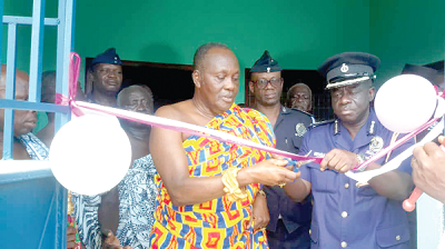 The two two-bedroom house donated by the Juaben Traditional Council. INSET: Daasebre Otuo Siriboe II being assisted by DCOP Mensah Duku to cut the tape to inaugurate the building