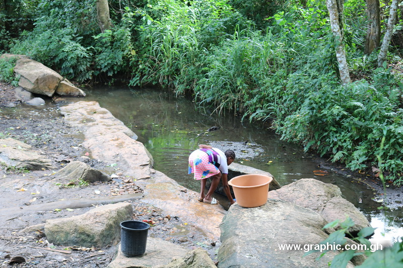 A young mother fetches water from the only source for inhabitants of Tetekasum