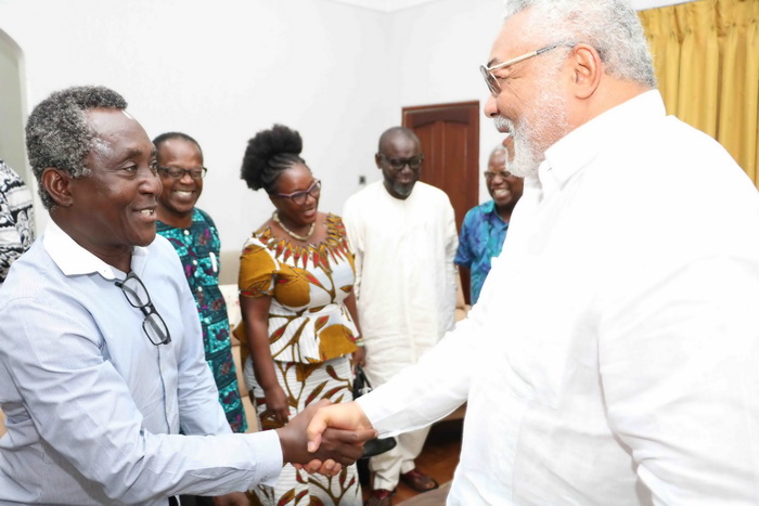 Co-Director of the play The Trial of JJ Rawlings in a handshake with JJ Rawlings