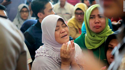 A relative of passengers prays as she and others wait for news on the Lion Air plane. A relative of passengers prays as she and others wait for news on the Lion Air plane.