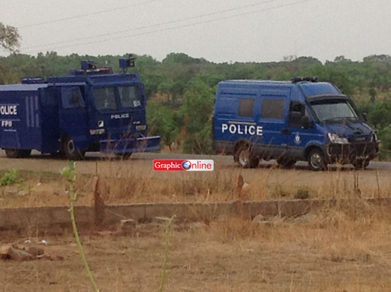 Police riot control vehicles parked on the road at the scene of the clash